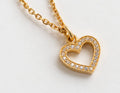 Dainty gold open heart pendant necklace with sparkling cubic zirconia stones, close up