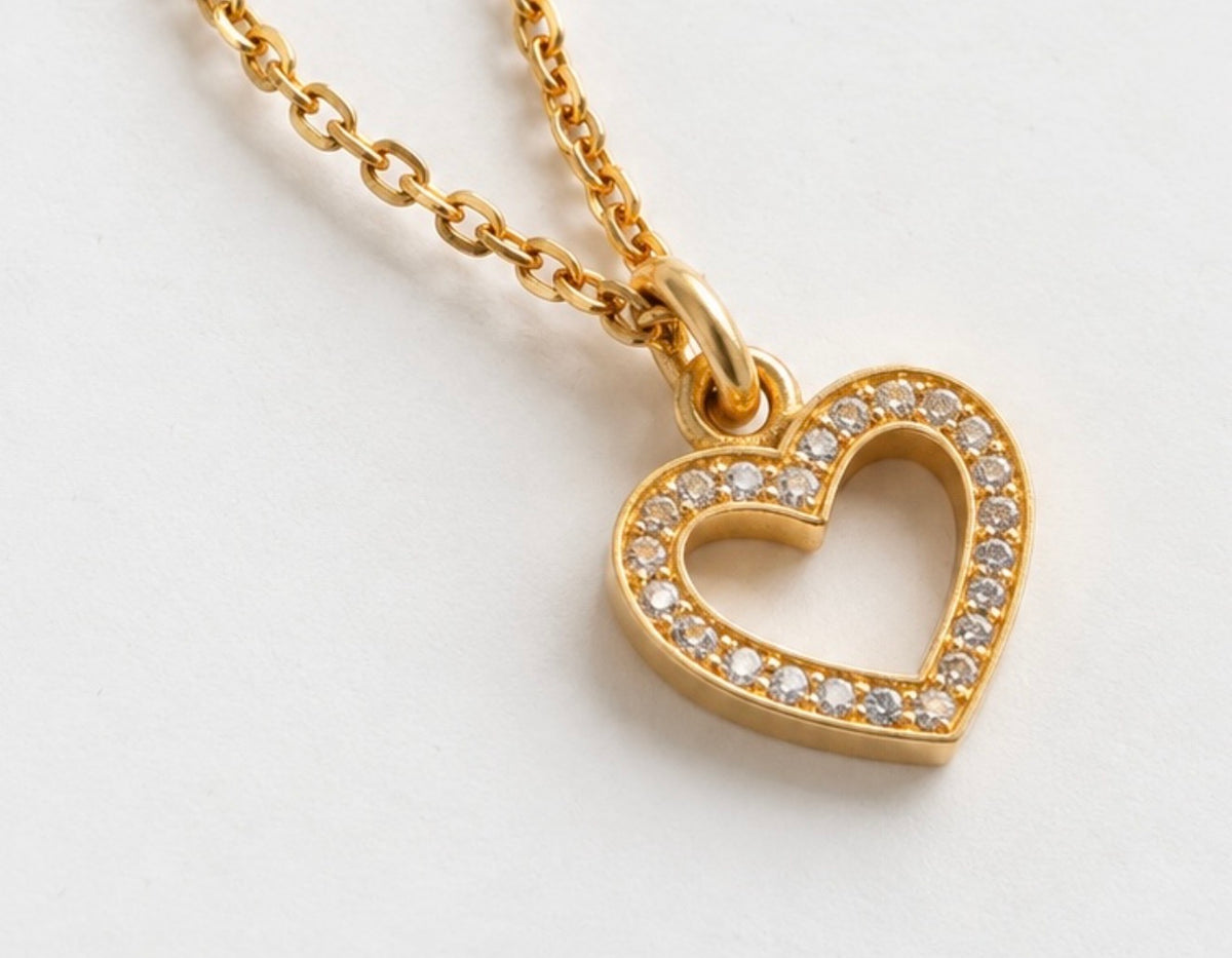 Dainty gold open heart pendant necklace with sparkling cubic zirconia stones, close up