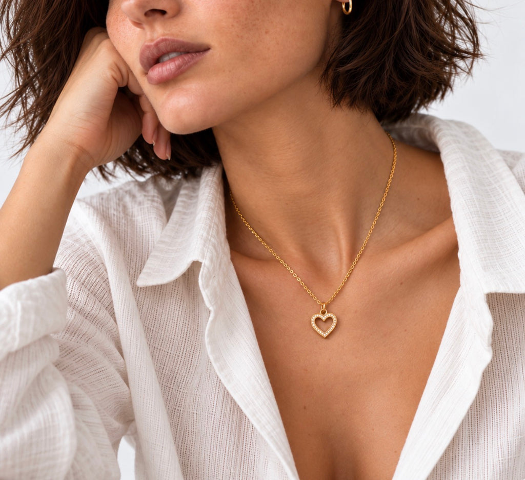 Woman wearing a dainty gold heart necklace, waterproof 18K gold PVD jewellery