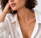 Woman wearing a dainty gold heart necklace, waterproof 18K gold PVD jewellery
