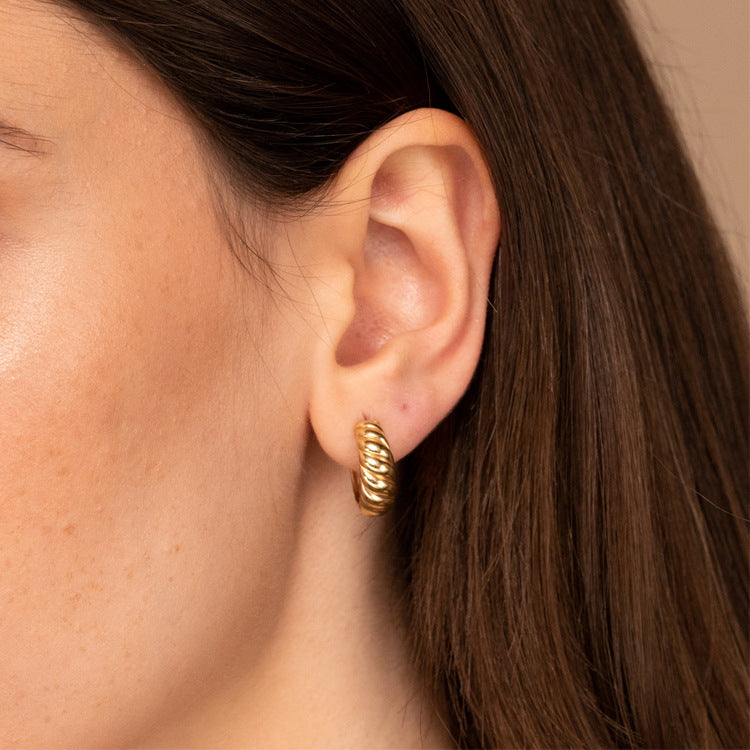 gold croissant hoop earrings worn on model ear
