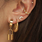 chunky oval gold hoop earrings worn on model ear