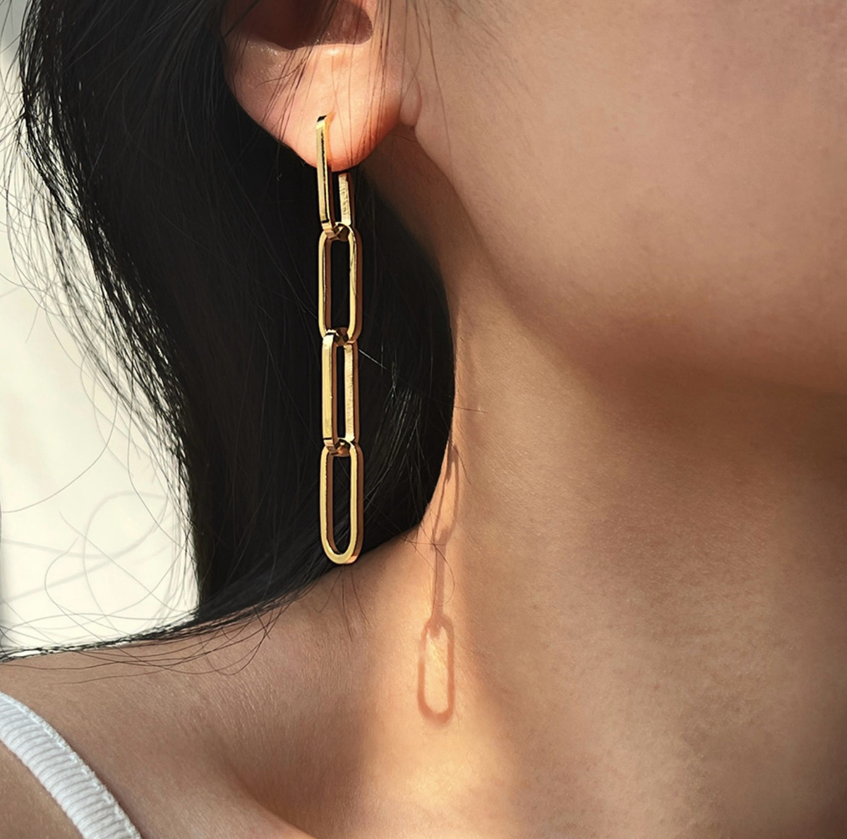 gold paperclip chain drop earrings worn on model ear