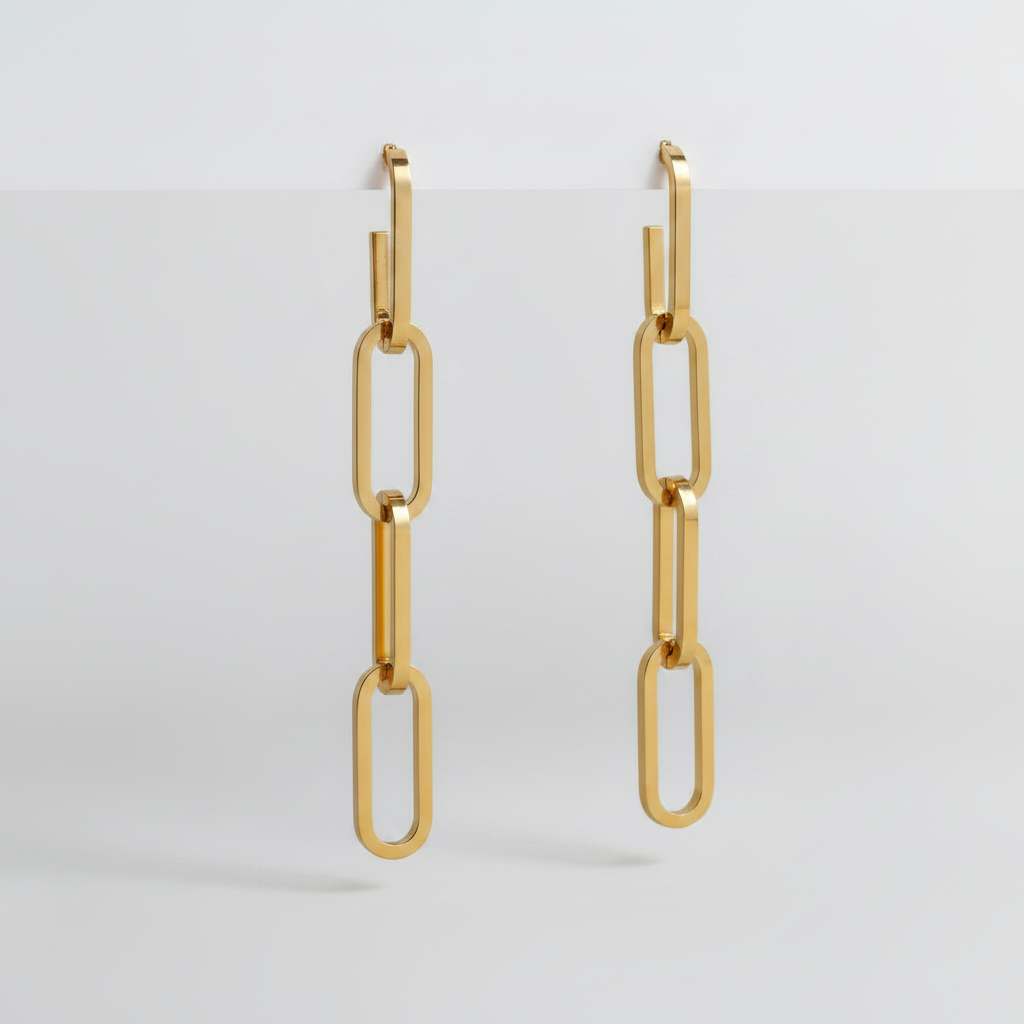 Gold paperclip-style earrings on a light gray background