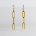 Gold paperclip-style earrings on a light gray background